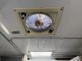 A ceiling vent fan with a metal frame and visible dust inside is mounted on the ceiling of a vehicle