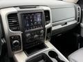 Interior dashboard of a 2018 RAM 1500 featuring a central touchscreen display with various controls and functions along with gear shifter and cup holders