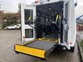 A 2021 Ford Transit-350 open at the back displaying a yellow wheelchair lift extending from the vehicle
