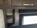 A wooden cabinet with a shelf and a red exit sign labeled "EXIT" and "SORTIE" attached to the wall