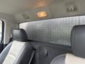 Interior view of a 2011 Dodge Ram 5500 featuring a leather seat in the foreground and a diamond plate metal panel in the rear window area