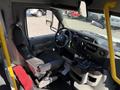 Interior view of a 2015 Ford Econoline showing the driver's seat dashboard and steering wheel with controls and gear shift