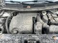 A 2016 Ford Explorer engine compartment with visible components including the engine cover air intake and various fluid reservoirs covered in dust and dirt
