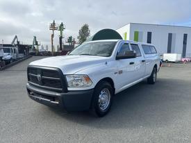 A white 2012 RAM 2500 pickup truck with a chrome grille and extended cab parked on a lot