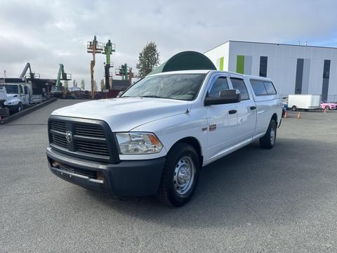 A white 2012 RAM 2500 pickup truck with a chrome grille and extended cab parked on a lot