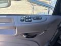 Interior door panel of a 2020 Peterbilt 330 featuring multiple control buttons for windows and locks