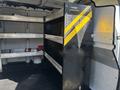 A black shelving unit with yellow stripes inside a 2019 GMC Savana designed for storage and organization