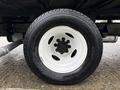 Close-up view of a white wheel with a black tire on a 2024 Ford E-450 showing detailed tread pattern and lug nut arrangement