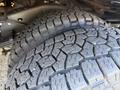 Close-up of two large, rugged tires with deep treads mounted on the undercarriage of a 2012 Ford Econoline E-450