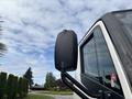 A close-up of the side mirror of a 2020 Lion Lion6 truck with a black casing and visible reflections in the glass