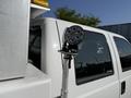 A 2015 Ford F-550 with a mounted spotlight attached to the side of the truck cab