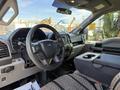 Interior view of a 2018 Ford F-150 showcasing the steering wheel dashboard and front seats with a console in the middle