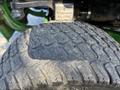 Close-up of a textured tire from a 2021 John Deere 1575 showing deep tread patterns and signs of wear