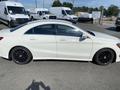 A white 2014 Mercedes-Benz CLA-Class sedan with black wheels, showcasing a sleek profile and modern design features