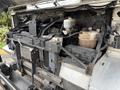 A 2012 Ford E-450 Super Duty engine compartment showcasing the engine components and cooling system with various hoses and tanks visible
