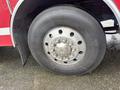 A close-up view of a large heavy-duty tire mounted on a fire truck with a metallic rim and several bolts visible around the hub