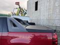 A 2011 Chevrolet Avalanche with a red exterior and a distinctive black bed cover showcasing a sleek design and angled rear windows