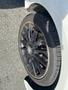 Close-up of a black alloy wheel from a 2014 Mercedes-Benz CLA-Class with a silver logo and worn tire tread