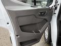 Interior door panel of a 2020 Ford Transit featuring a large storage compartment and control buttons for windows and locks