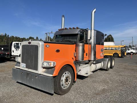 A 2009 Peterbilt Highway truck with an orange and black color scheme featuring chrome accents and dual exhaust stacks