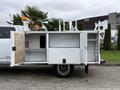 A 2013 RAM 3500 work truck with a service body featuring multiple storage compartments and orange warning lights mounted on the roof