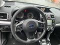 Interior view of a 2016 Subaru Forester showcasing the steering wheel dashboard and central console with controls and a display screen