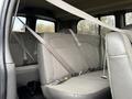 The interior of a 2023 GMC Savana featuring rear bench seats with seat belts securely fastened