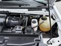 The engine bay of a 2013 Ford E-350 featuring the air intake system and various fluid reservoirs including coolant and power steering fluid