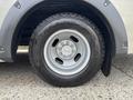 A close-up of a silver wheel with a five-bolt pattern and a Goodyear Wrangler tire mounted on a 2020 Chevrolet Express