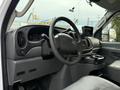 Interior view of a 2007 Ford E-350 showcasing the steering wheel dashboard and console with cup holders