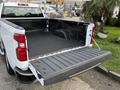 2024 Chevrolet Silverado 1500 pickup truck with an open tailgate and a rubber bed liner visible in the cargo area