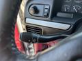 Close-up of the turn signal lever controls of a 1995 Ford F-250 with various buttons for lights and fuel indicator on the dashboard in the background