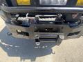 Close-up view of a front bumper of a 2016 Ford F-350 SD featuring a winch and towing attachments