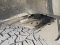 A close-up view of the undercarriage of a 2022 GMC Savana showcasing part of the suspension system and a portion of the tire tread