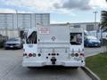 A 2008 Ford F-450 truck with a diamond plate exterior featuring a warning sign that says CAUTION FREQUENT STOPS and equipped with hoses and various tool storage compartments
