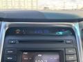 The dashboard display of a 2014 Hyundai Sonata showing time and outside temperature along with various audio controls and settings