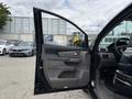 A black 2014 Honda Odyssey with the driver's side door open showcasing the interior features and controls