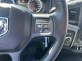 Close-up of the steering wheel of a 2015 RAM 1500 showing control buttons for cruise control and a textured grip