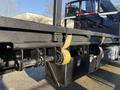 A close-up view of the rear loading area of a 2015 Hino 358 featuring heavy-duty straps and a storage compartment attached to the chassis