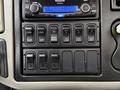 The interior control panel of a 2012 International 7400 featuring various switches and a radio display