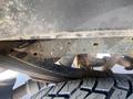 Undercarriage of a 2016 Ford F-350 SD showing rusted metal components and tire tread visible in the foreground