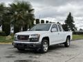 A white 2012 GMC Canyon pickup truck with a crew cab parked on a pavement surface