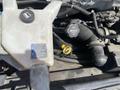 A 2020 Chevrolet Express engine compartment featuring a coolant reservoir and a yellow cap for the oil fill with surrounding hoses and wires