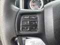 Close-up of the steering wheel controls of a 2016 RAM 1500 featuring buttons for voice control navigation and phone functions