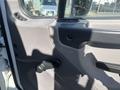 The interior door panel of a 2022 Freightliner M2 106 featuring a window crank handle and control buttons in a gray textured finish