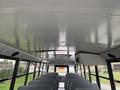 Interior view of a 2022 Freightliner B2 school bus showing rows of gray seats and a white ceiling with ventilation system