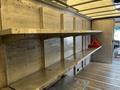 Interior view of a 2011 Ford Econoline van showing empty metal shelves and a red warning triangle on a shelf