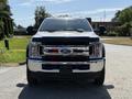 A white 2019 Ford F-550 truck is shown from the front with a chrome grille and large tires