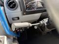 A close-up of a 2022 Lion Lion6 vehicle's control stick featuring various switches and dials for functions like wipers and turn signals