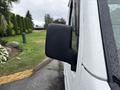 A close-up view of the side mirror of a 2008 Suzuki Carry showing a black plastic casing with water droplets on it